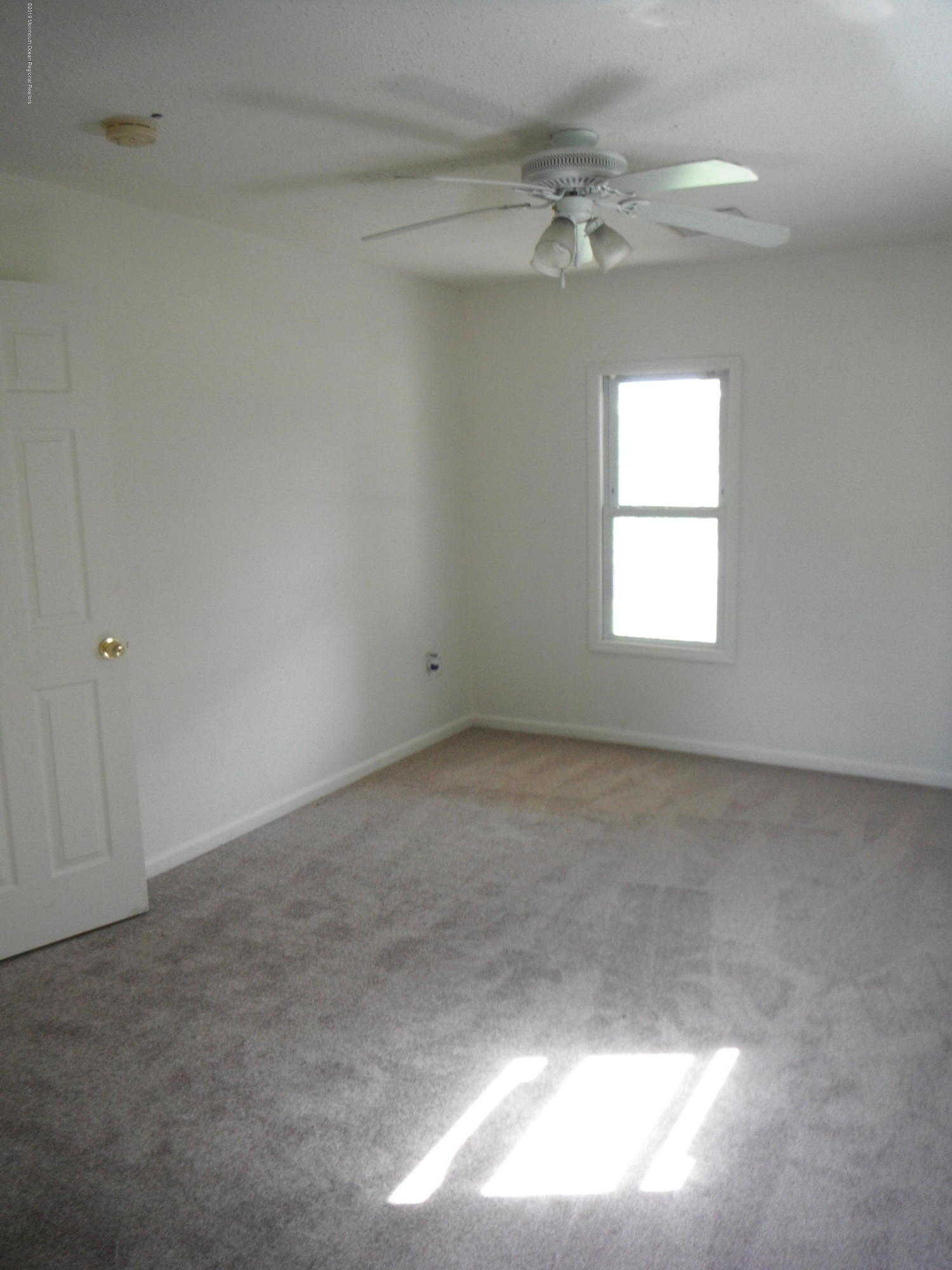 3 Colonial Drive Little Egg Harbor, NJ 08087 - Photo 16 of 21 en empty room with windows and chandelier fan