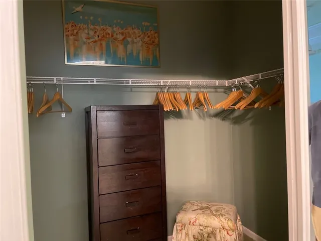 a view of walk in closet with clothes