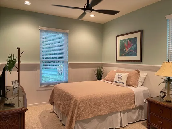 a bedroom with a large bed and a potted plant