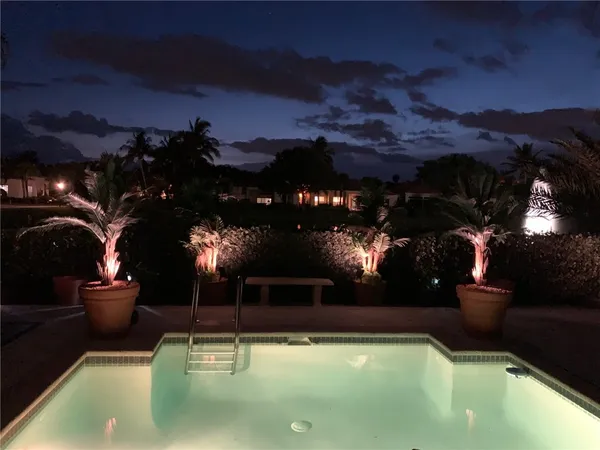 a view of a swimming pool with a table fire pit and a fountain