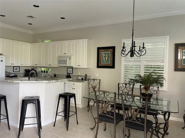 a kitchen with stainless steel appliances a white table and chairs in it