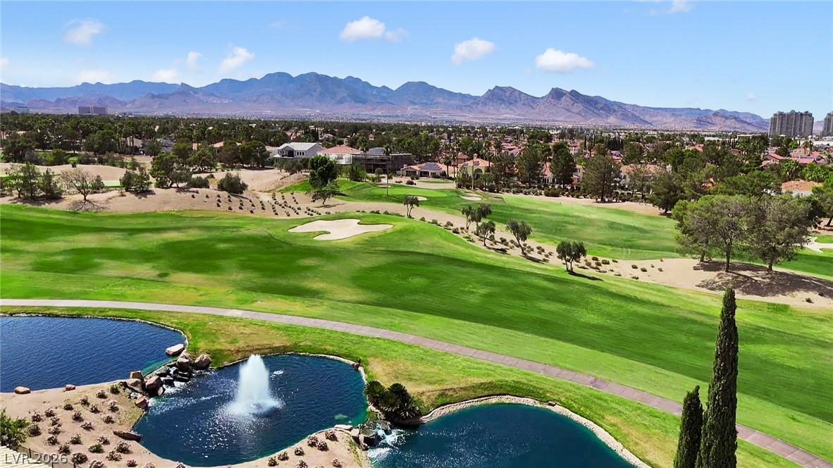 8981 Rivers Edge Drive Las Vegas, NV 89117 - Photo 69 of 69 A vibrant green golf course unfolds with serene water features and a distant mountain backdrop.