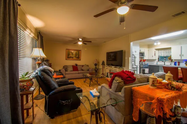 a living room with furniture kitchen view and a large window