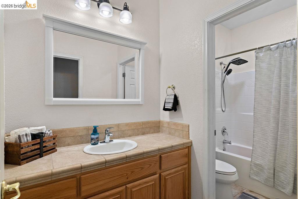 4955 Little John Road Copperopolis, CA 95228 - Photo 19 of 60 a bathroom with a granite countertop sink a toilet and a mirror