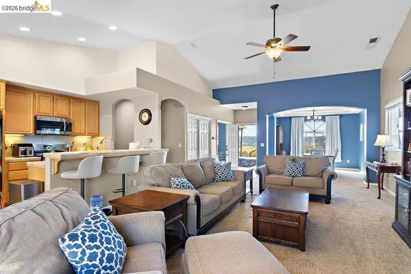 a living room with furniture kitchen and a chandelier
