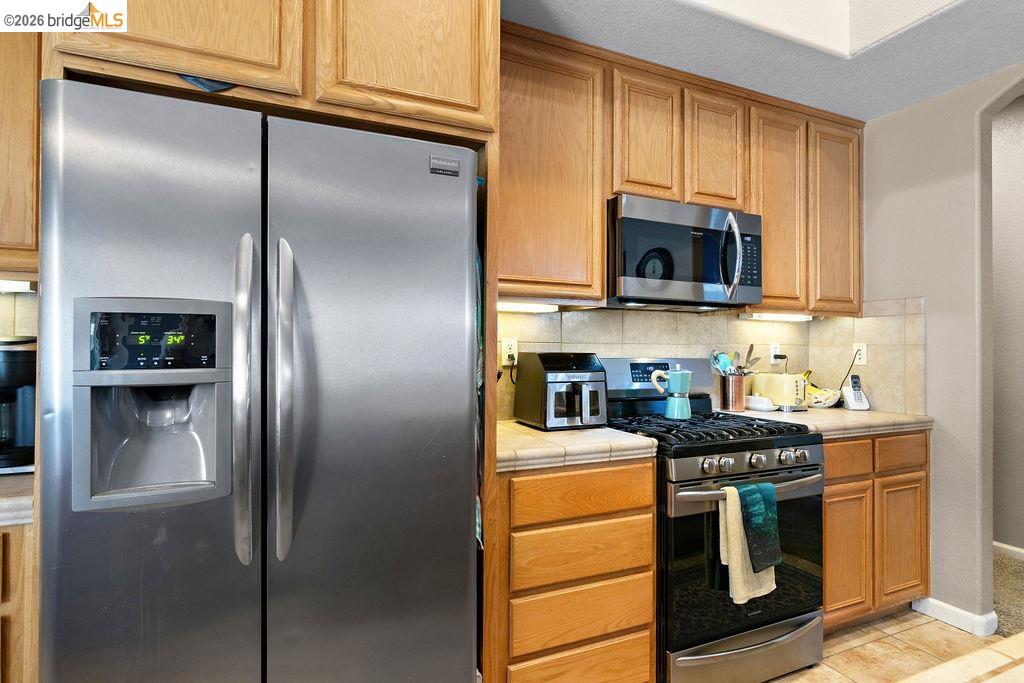 4955 Little John Road Copperopolis, CA 95228 - Photo 45 of 60 a kitchen with stainless steel appliances granite countertop a refrigerator stove and microwave