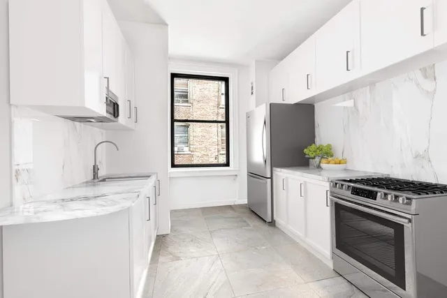 a view of an empty room with window and closet area