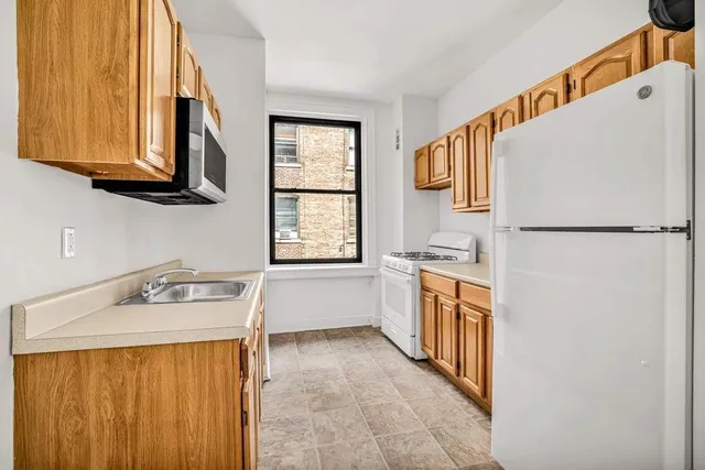 a kitchen with granite countertop a stove sink and cabinets