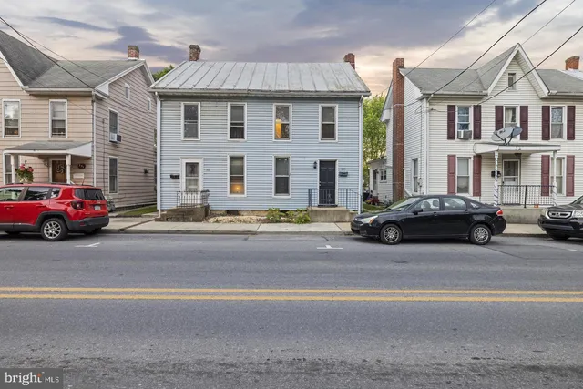 a car parked in front of a white house