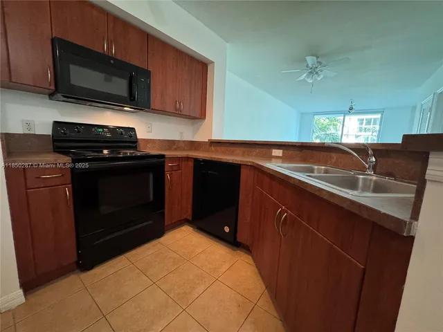 a kitchen with stainless steel appliances kitchen island a sink stove and refrigerator