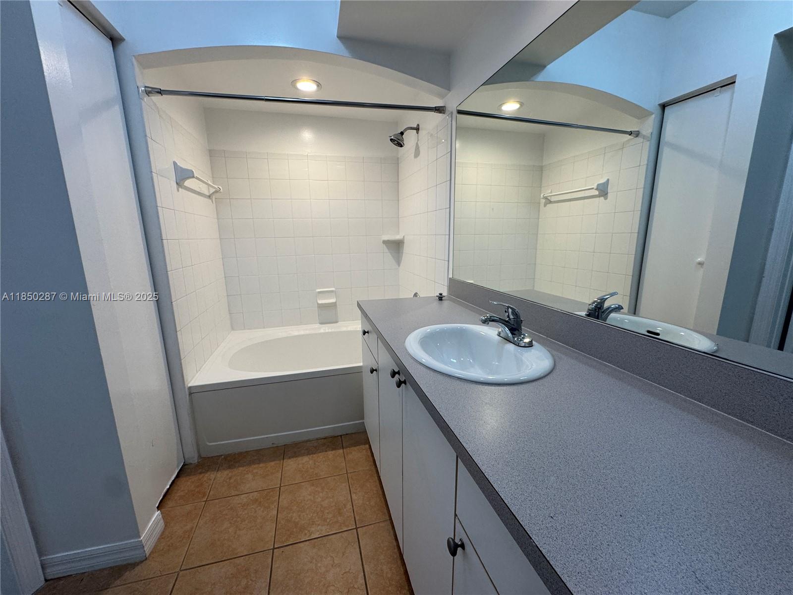 9201 Collins Avenue, Unit 323 Surfside, FL 33154 - Photo 18 of 46 a bathroom with a granite countertop sink and a mirror