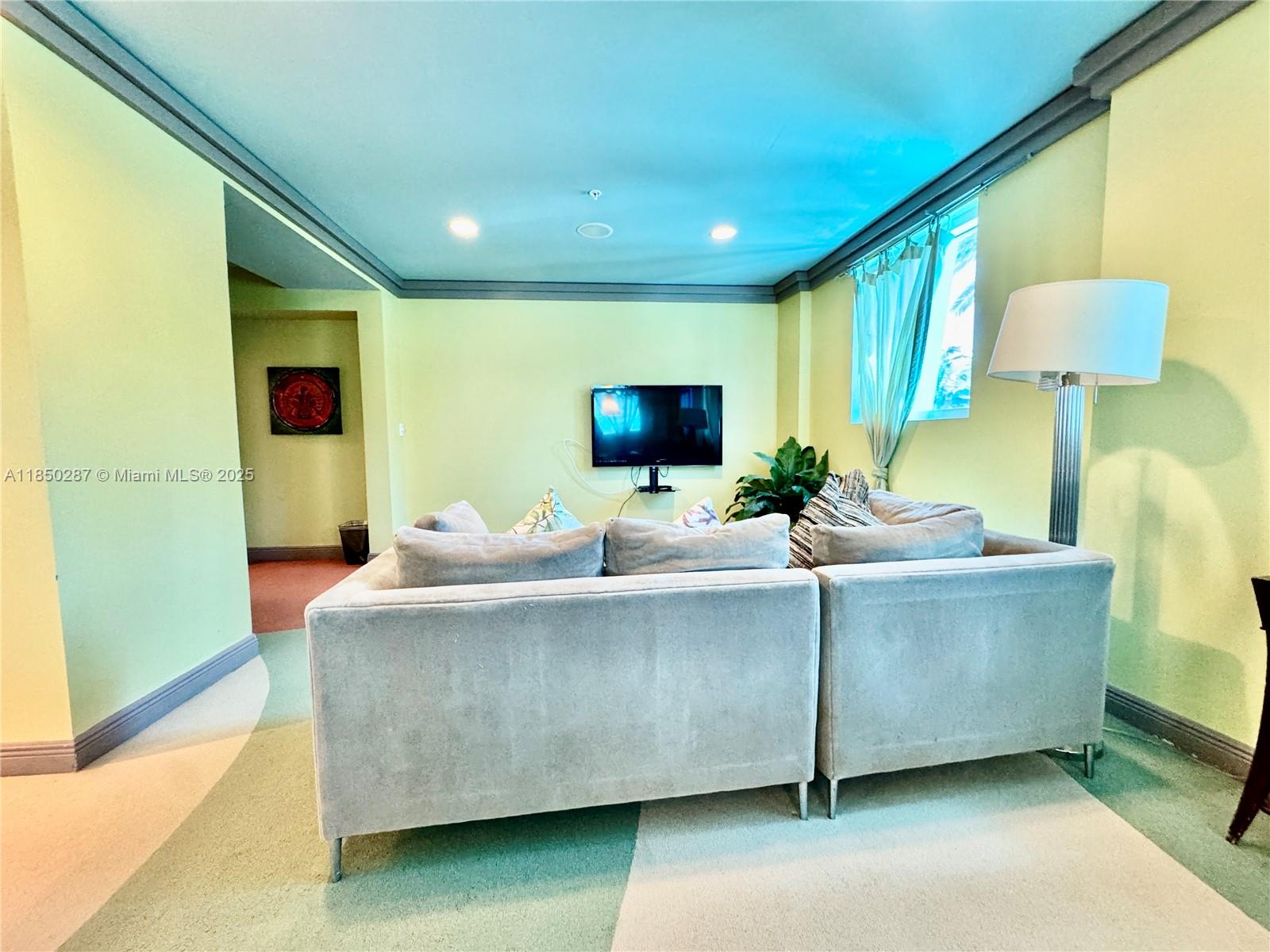 9201 Collins Avenue, Unit 323 Surfside, FL 33154 - Photo 29 of 46 a living room with furniture and a flat screen tv