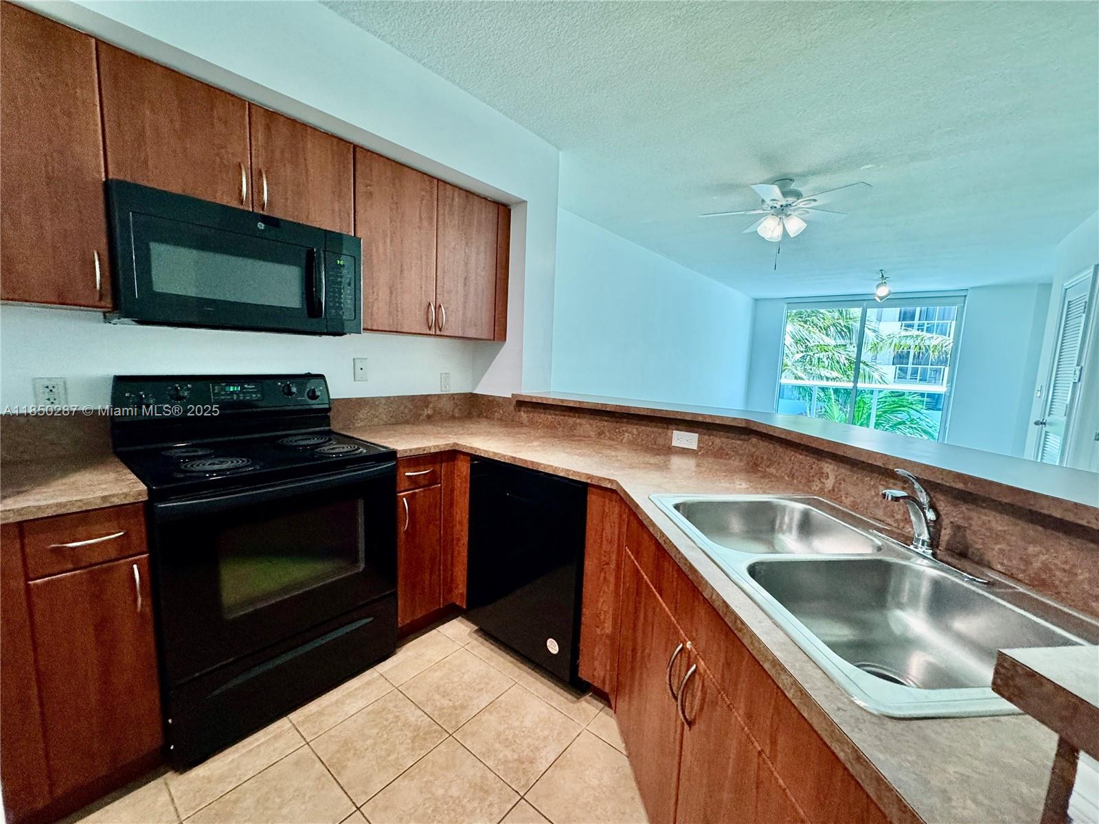 9201 Collins Avenue, Unit 323 Surfside, FL 33154 - Photo 36 of 46 a kitchen with a sink stove and microwave