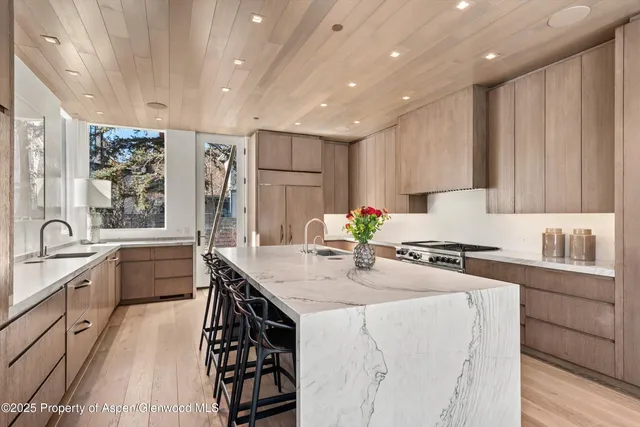 a living room with furniture a large window and a potted plant