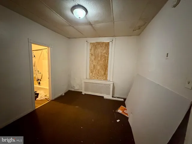 a large bedroom with a bed and wooden floor