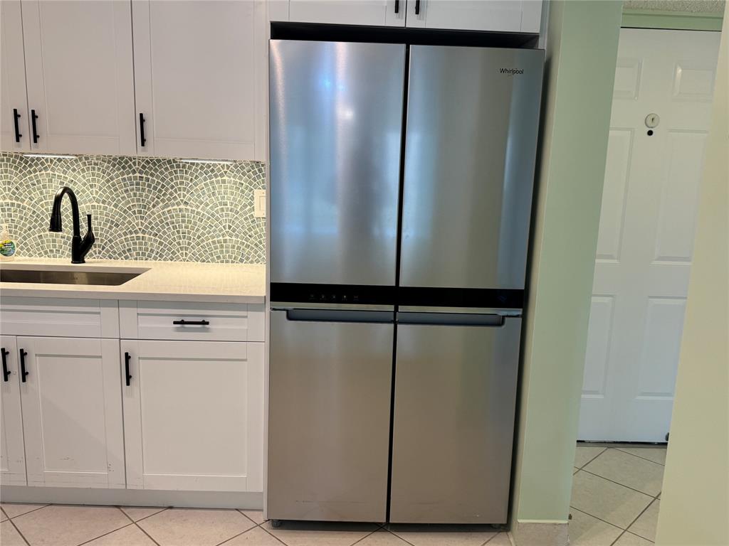 9300 Southwest 8th Street, Unit 215 Boca Raton, FL 33428 - Photo 24 of 43 a kitchen with a refrigerator and cabinets