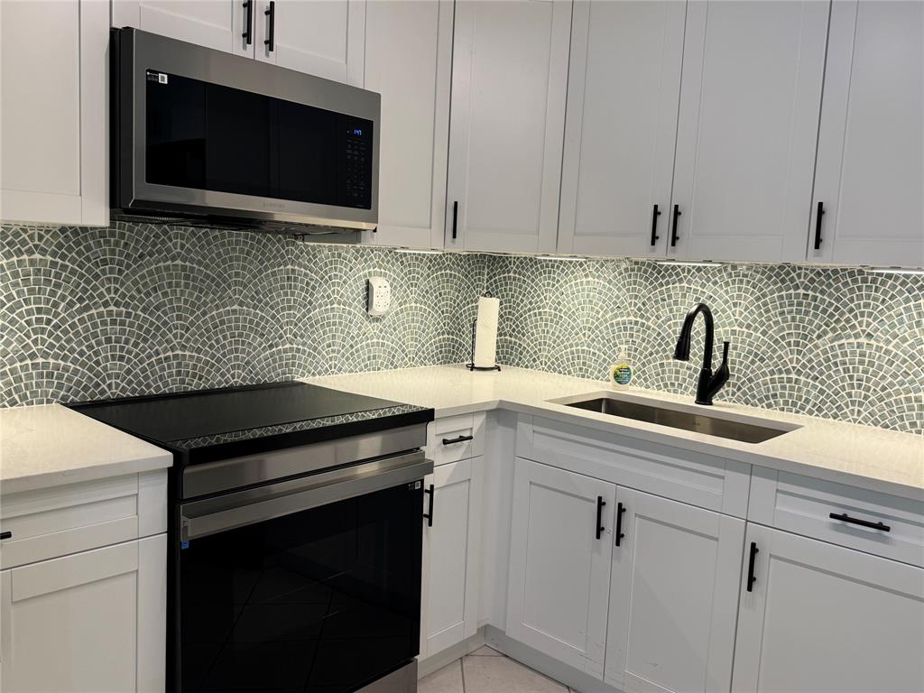 9300 Southwest 8th Street, Unit 215 Boca Raton, FL 33428 - Photo 25 of 43 a kitchen with a sink and cabinets