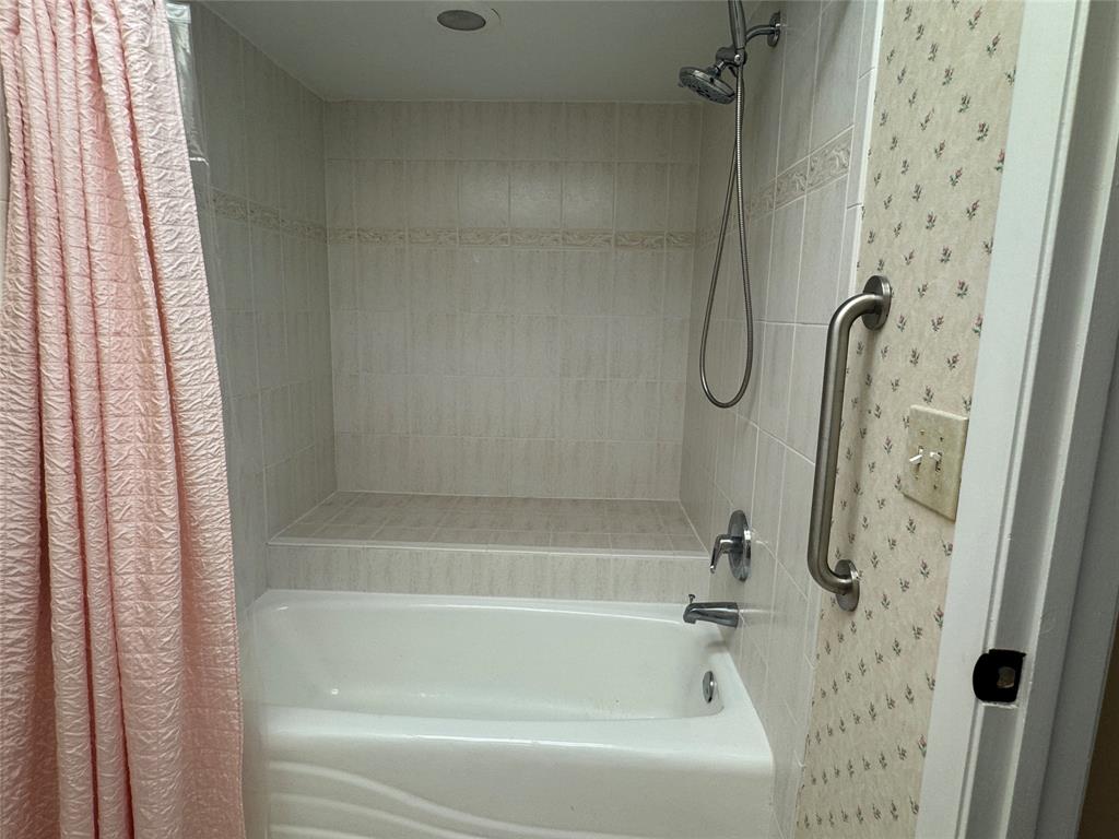 9300 Southwest 8th Street, Unit 215 Boca Raton, FL 33428 - Photo 34 of 43 a bath tub sitting next to a shower curtain