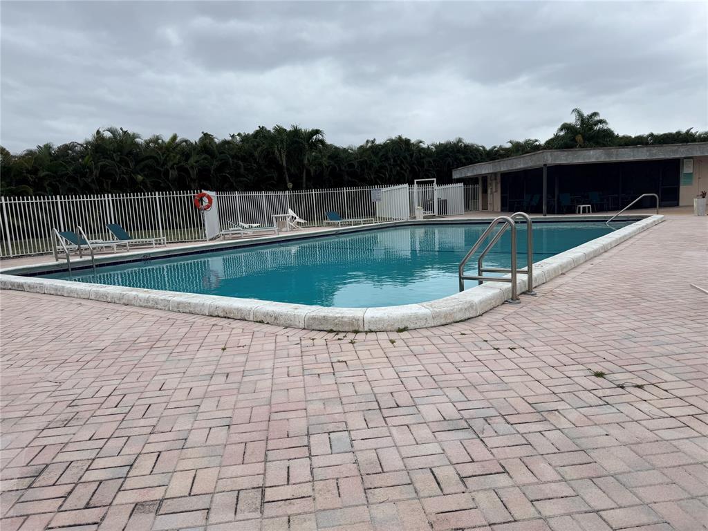 9300 Southwest 8th Street, Unit 215 Boca Raton, FL 33428 - Photo 6 of 43 a view of a swimming pool with a yard