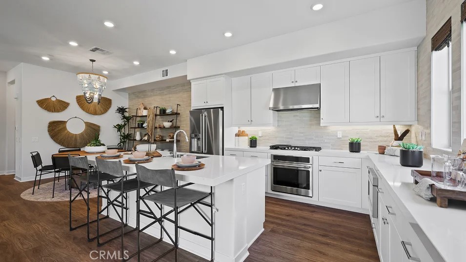995 Walnut Terrace Montebello, CA 90640 - Photo 1 of 1 a kitchen with stainless steel appliances kitchen island granite countertop a stove a sink a refrigerator and white cabinets with wooden floor