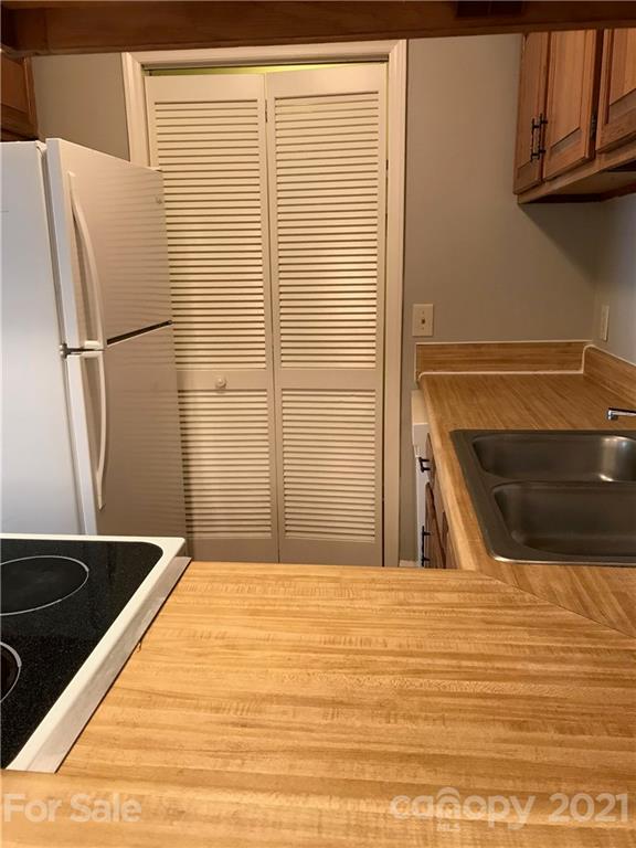 1604 Sharon Road West, Unit 22 Charlotte, NC 28210 - Photo 12 of 23 a kitchen with stainless steel appliances kitchen island a refrigerator sink and stove
