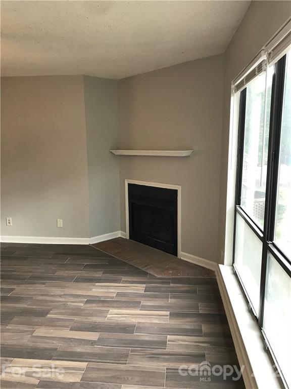 1604 Sharon Road West, Unit 22 Charlotte, NC 28210 - Photo 5 of 23 a view of empty room with wooden floor and fireplace