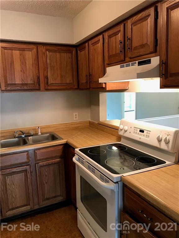 1604 Sharon Road West, Unit 22 Charlotte, NC 28210 - Photo 10 of 23 a kitchen with wooden cabinets and a stove top oven