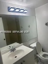 a bathroom with a sink a toilet and mirror