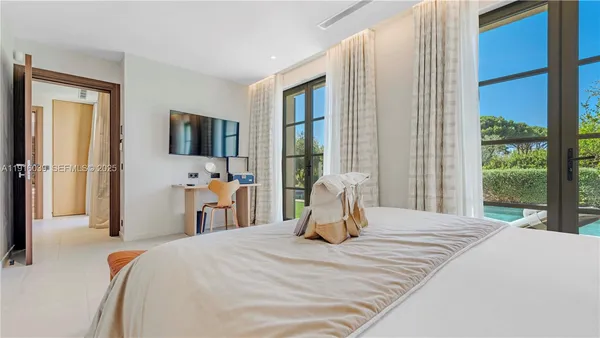 a bedroom with a bed and a flat screen tv