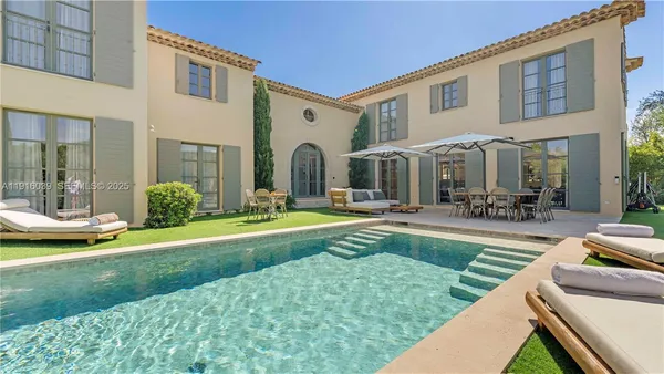 a view of a patio with a table and chairs under an umbrella