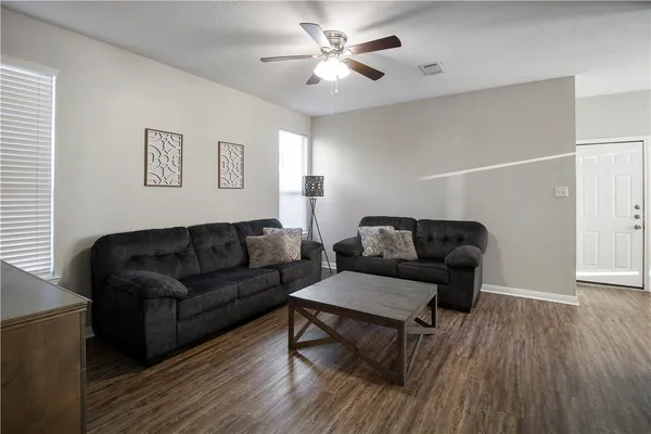 a living room with furniture and a wooden floor