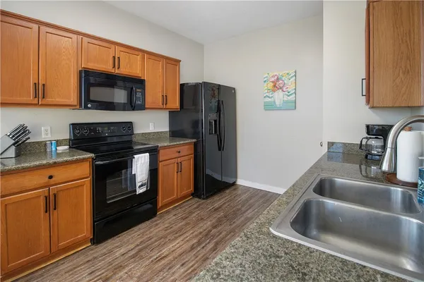 a kitchen with stainless steel appliances granite countertop a refrigerator stove top oven and sink