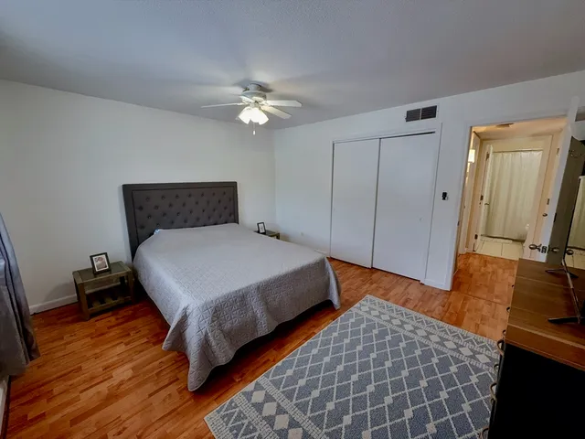 a bedroom with a bed and a flat tv screen on a dresser