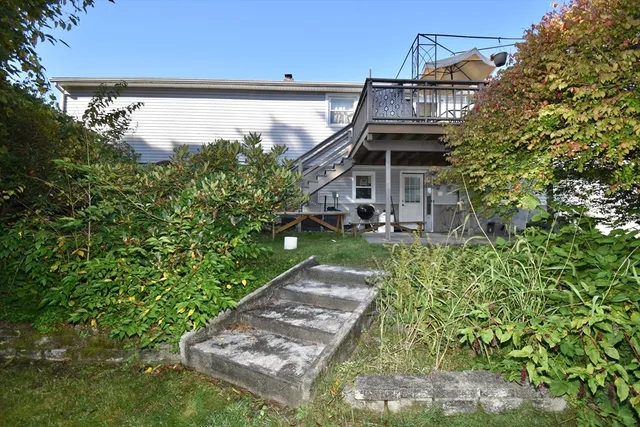 a backyard of a house with plants and large trees