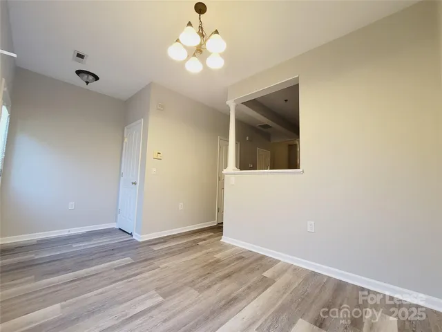en empty room with wooden floor and a ceiling fan