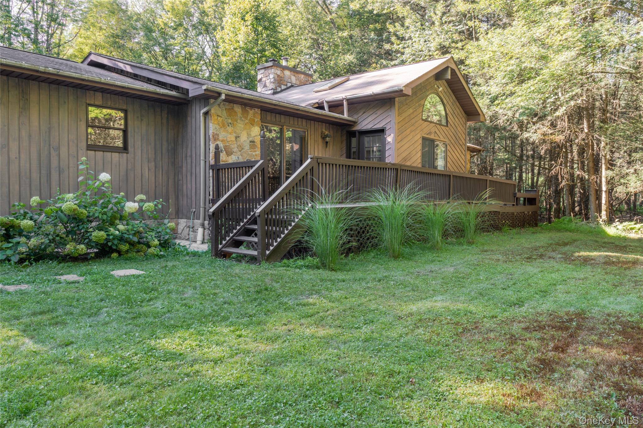 15 Deer Meadow Road Bethel, NY 12720 - Photo 11 of 41 Rear view of property featuring a wooden deck, a yard, a chimney, and stairs