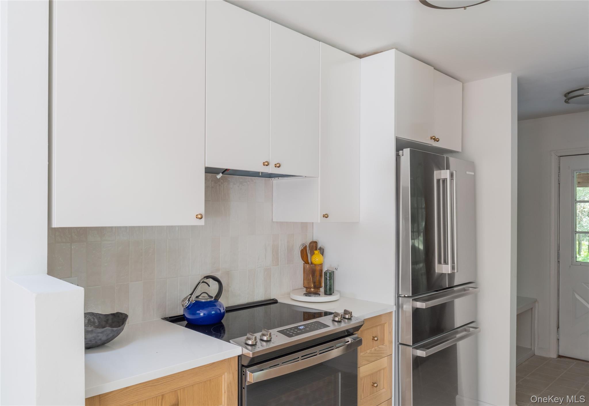 15 Deer Meadow Road Bethel, NY 12720 - Photo 15 of 41 Kitchen featuring stainless steel appliances, tasteful backsplash, white cabinets, and light stone countertops