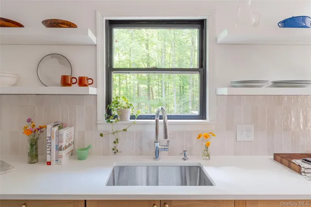 a kitchen with a window a sink and a wooden floor