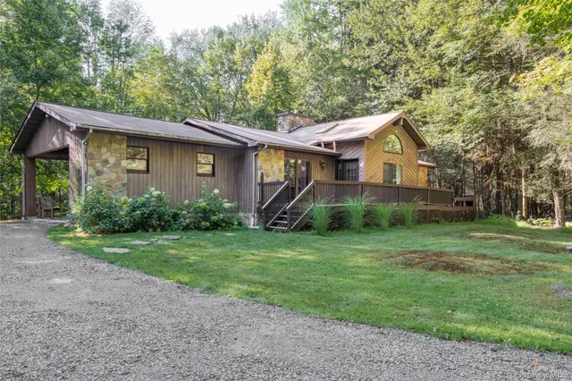 a view of backyard with table and chairs and floor to ceiling window with yard