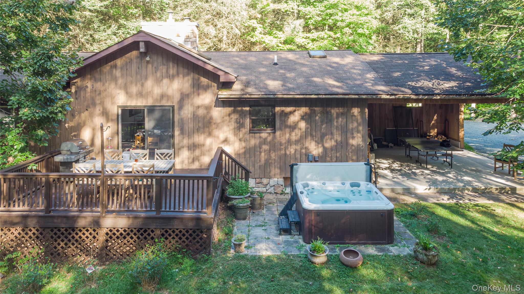 15 Deer Meadow Road Bethel, NY 12720 - Photo 33 of 41 Back of property featuring a hot tub, a shingled roof, a patio, and a deck