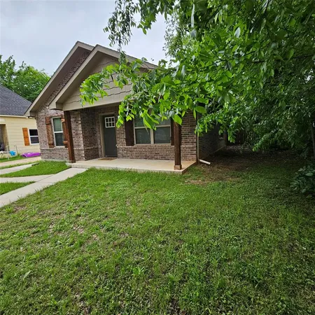 a front view of a house with a yard and trees