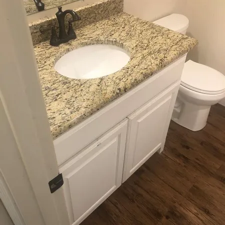 a bathroom with a granite countertop sink and a mirror