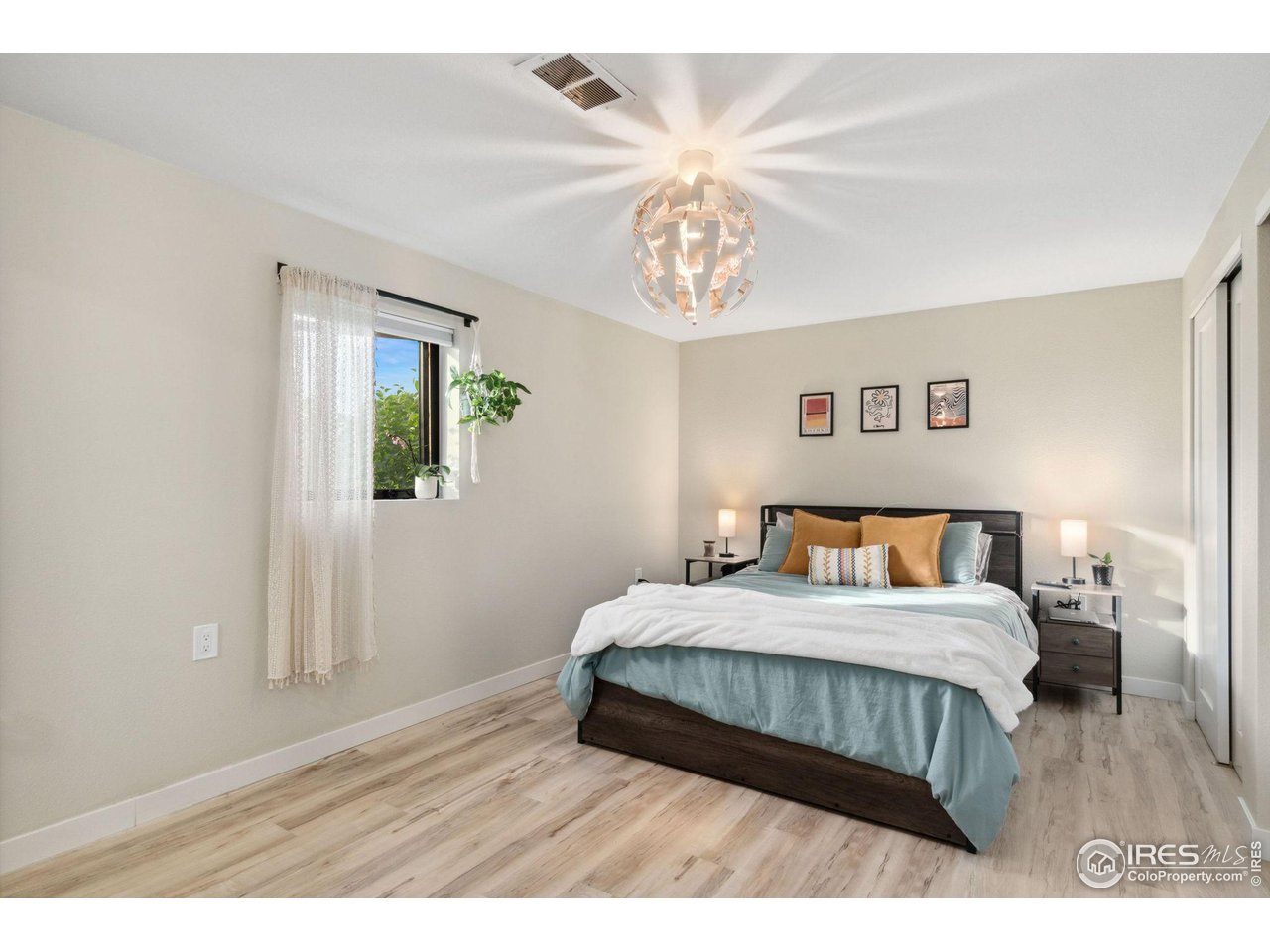 8861 Marathon Road Niwot, CO 80503 - Photo 29 of 40 a bedroom with a large bed and a chandelier