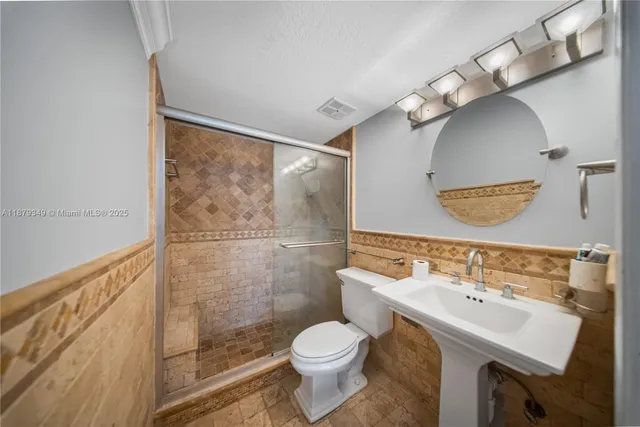 a bathroom with a sink mirror toilet and shower