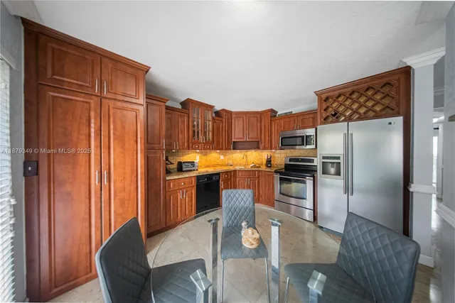 a kitchen with stainless steel appliances granite countertop a refrigerator a stove and a sink with wooden floor