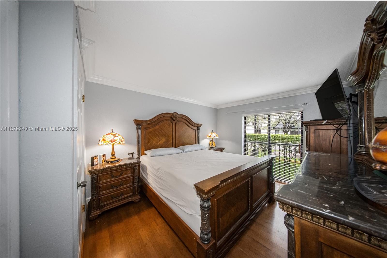 13045 Southwest 68th Street, Unit 103 Miami, FL 33183 - Photo 7 of 13 a bedroom with a bed and a flat screen tv