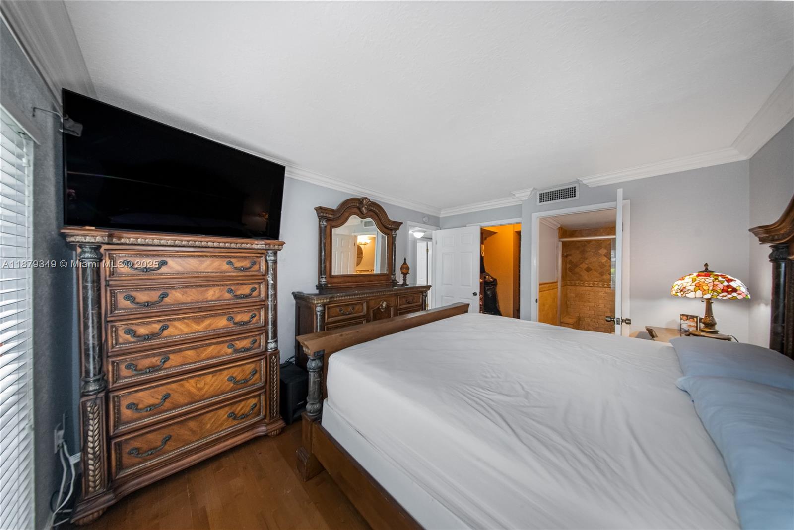 13045 Southwest 68th Street, Unit 103 Miami, FL 33183 - Photo 8 of 13 a bedroom with a bed and a flat screen tv