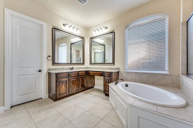a bathroom with a tub sink and mirror