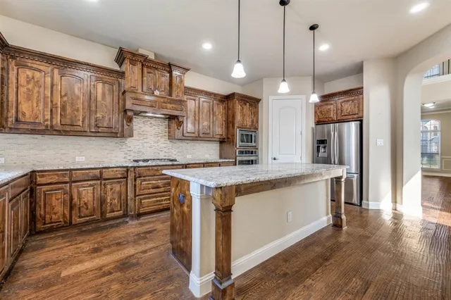 a kitchen with stainless steel appliances granite countertop wooden floors sink and cabinets