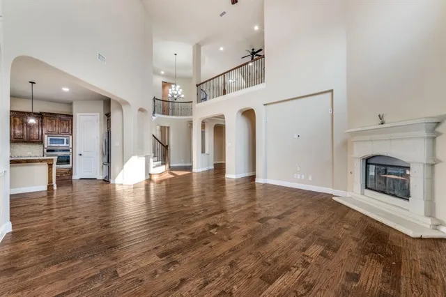 an empty room with wooden floor and a fireplace